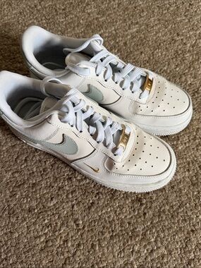 Nike Women's White Sneakers with Light Gray Swoosh and Gold Accents